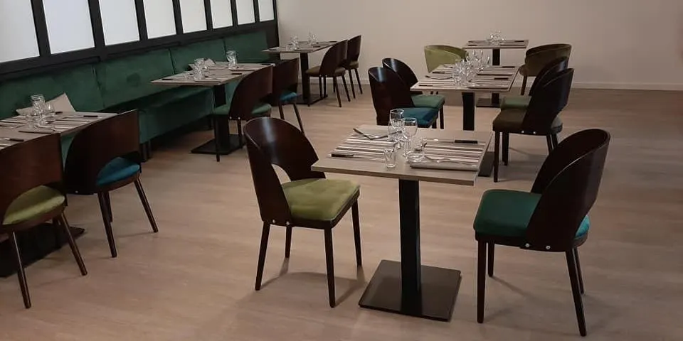 Salle du restaurant des Feuillardiers avec tables dressées et grandes fenêtres
