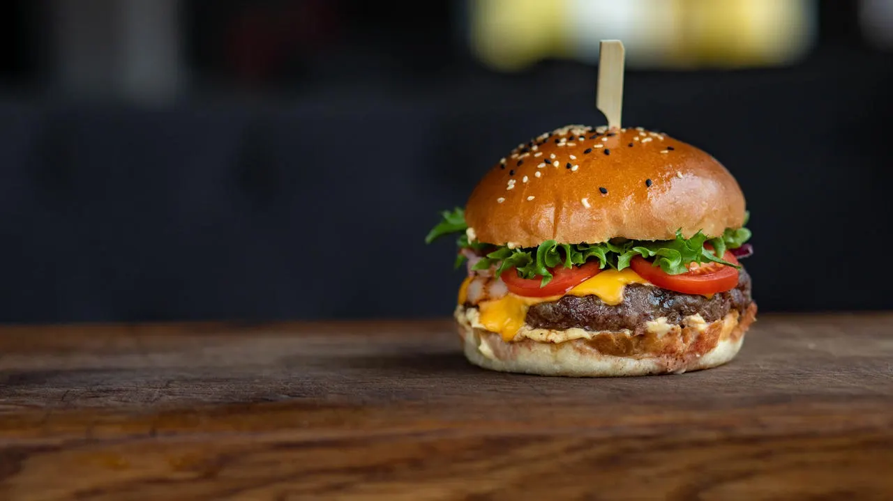 Burger du moment avec pain au sésame, laitue, tomate, fromage et galette de bœuf