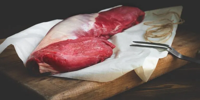 Illustration L'exigence de la qualité : pièces de viande fraîche sur planche à découper en bois