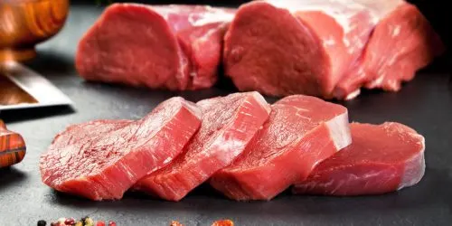 Tranches de viande de bœuf fraîchement découpées avec un couteau et du poivre